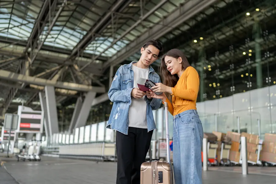 Pareja revisando sus pasaportes y tarjetas de embarque en la terminal